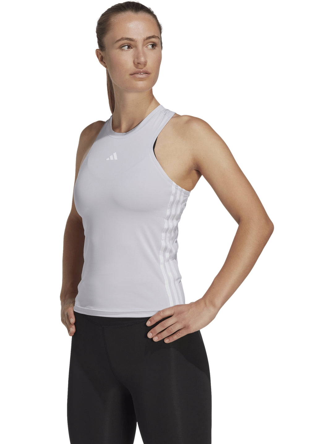 Mujer vistiendo una camiseta deportiva Adidas sin mangas en color silver dawn con detalles blancos laterales.