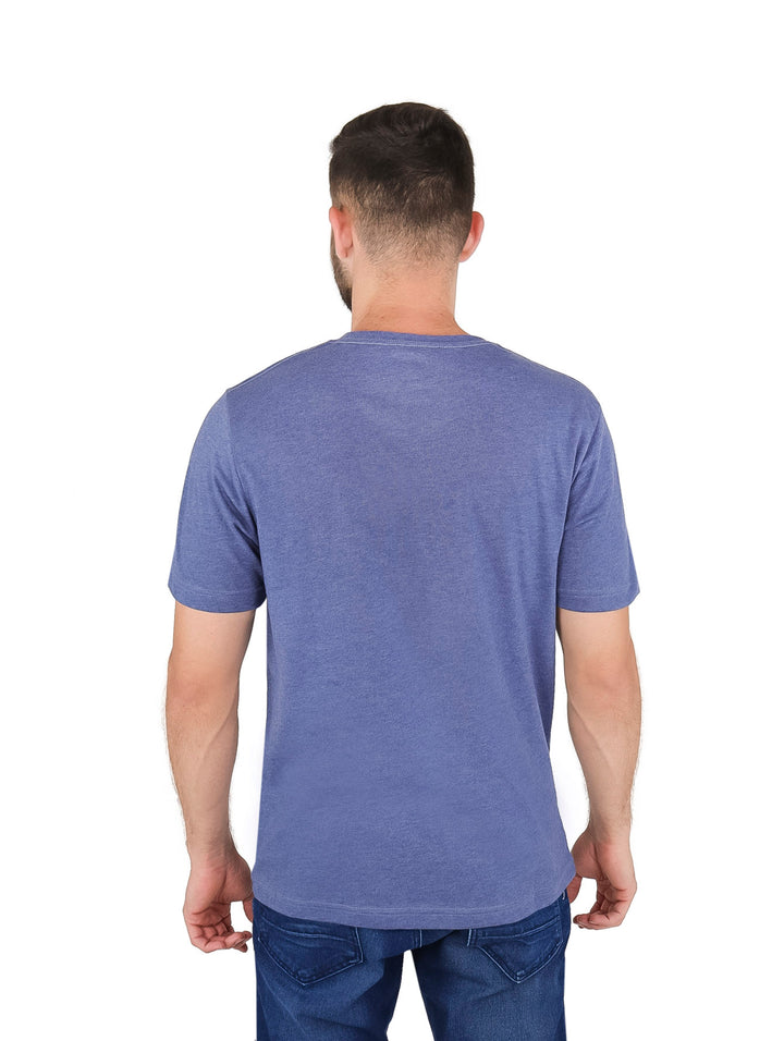 Hombre vistiendo playera azul de manga corta marca Lee con logotipo rojo en el pecho.