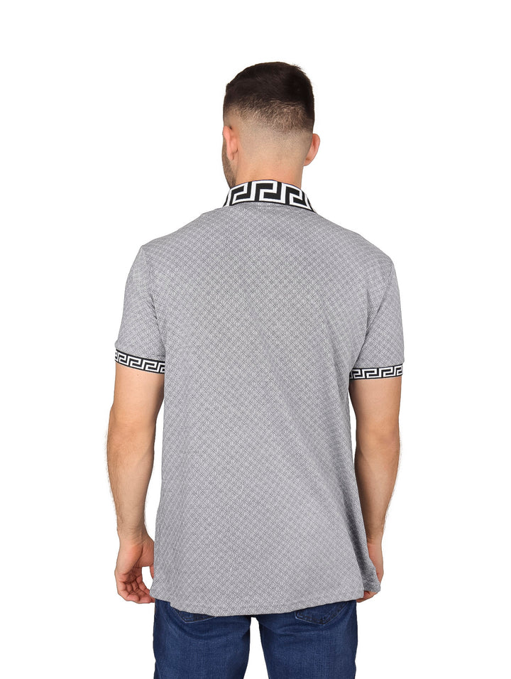 Hombre usando playera polo negra con estampado y bordes decorativos en el cuello y mangas.