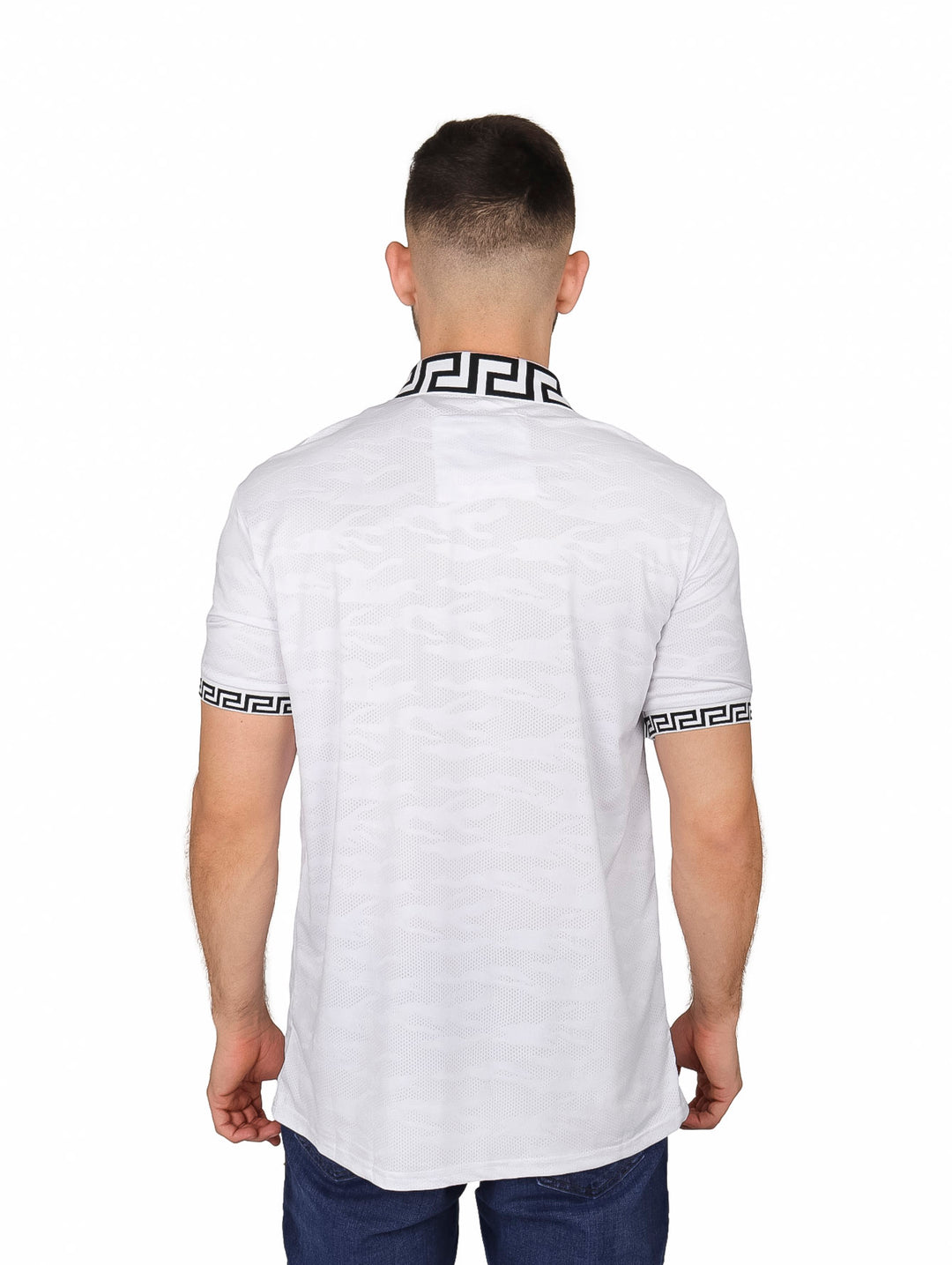 Hombre vistiendo playera polo blanca con detalles decorativos negros en cuello y mangas.