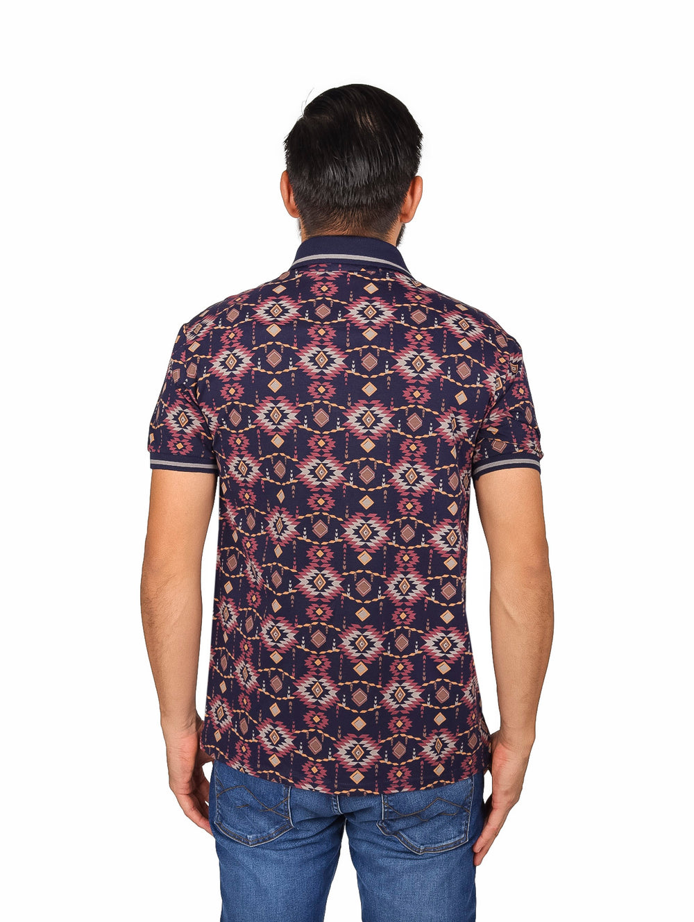 Hombre vistiendo playera polo azul marino con estampado geométrico multicolor y jeans azules.