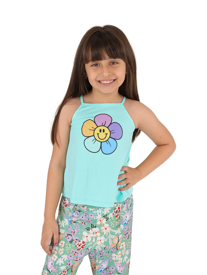 Niña vistiendo un top deportivo color aqua con estampado de flor y pantalones florales.