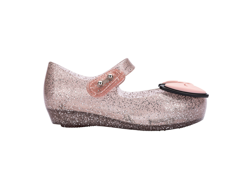 Sandalias infantiles Mini Melissa color rosa con glitter y un moño decorativo en la parte frontal.
