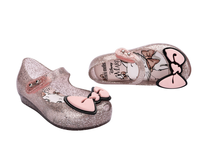 Sandalias infantiles Mini Melissa color rosa con glitter y un moño decorativo en la parte frontal.