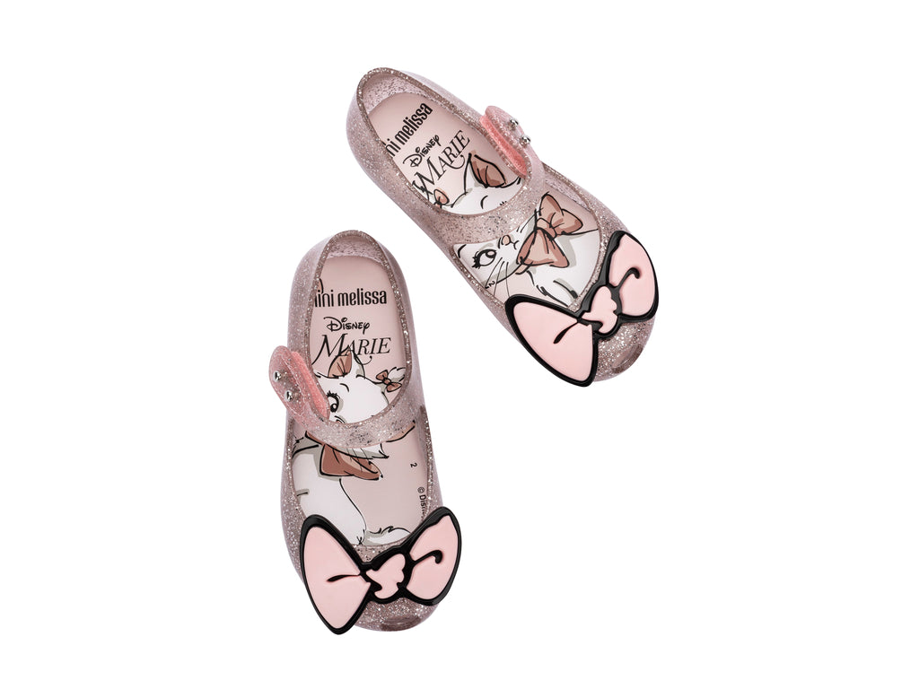 Sandalias infantiles Mini Melissa color rosa con glitter y un moño decorativo en la parte frontal.