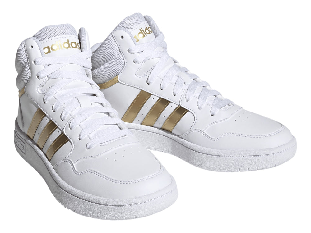 Tenis Adidas Hoops 3.0 Mid color blanco con franjas laterales doradas.