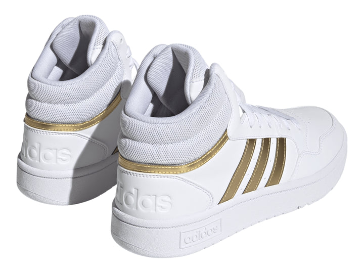 Tenis Adidas Hoops 3.0 Mid color blanco con franjas laterales doradas.