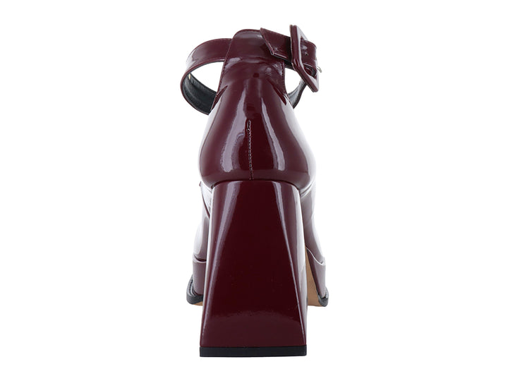 Zapato de tacón alto y plataforma color rojo cabernet con acabado brillante de charol y correa al tobillo.
