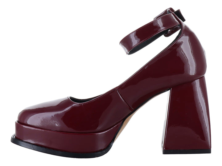 Zapato de tacón alto y plataforma color rojo cabernet con acabado brillante de charol y correa al tobillo.