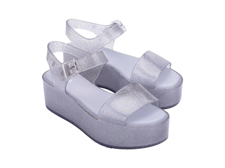Sandalia de plataforma transparente con glitter y correa con hebilla.