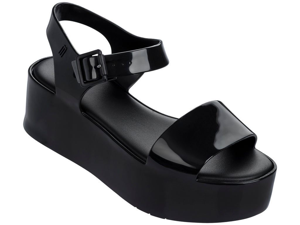 Sandalia Melissa de plataforma alta en color negro brillante con correa ajustable al tobillo.