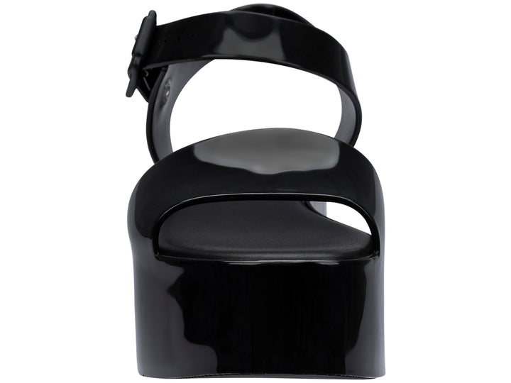 Sandalia Melissa de plataforma alta en color negro brillante con correa ajustable al tobillo.