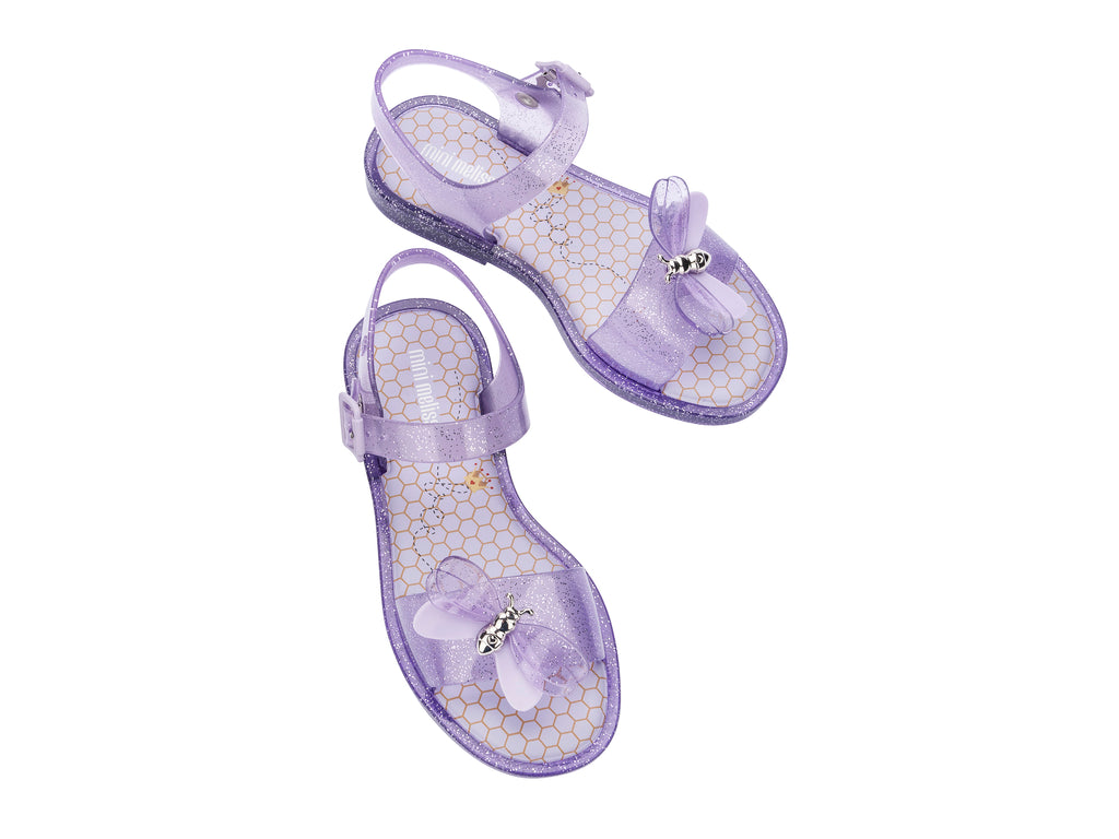 Sandalias moradas brillantes para niña con adorno de mariposa y suela con glitter.