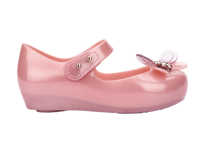 Zapato rosa brillante para bebé estilo Mary Jane con correa y detalle de moño transparente.