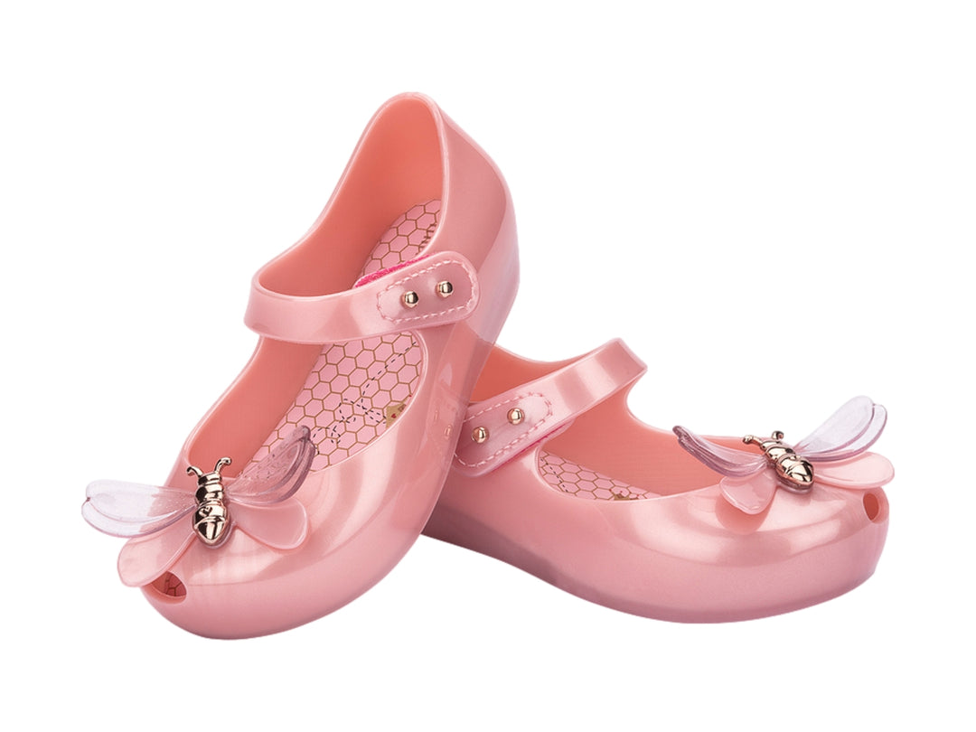 Zapato rosa brillante para bebé estilo Mary Jane con correa y detalle de moño transparente.