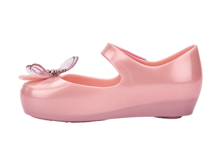 Zapato rosa brillante para bebé estilo Mary Jane con correa y detalle de moño transparente.