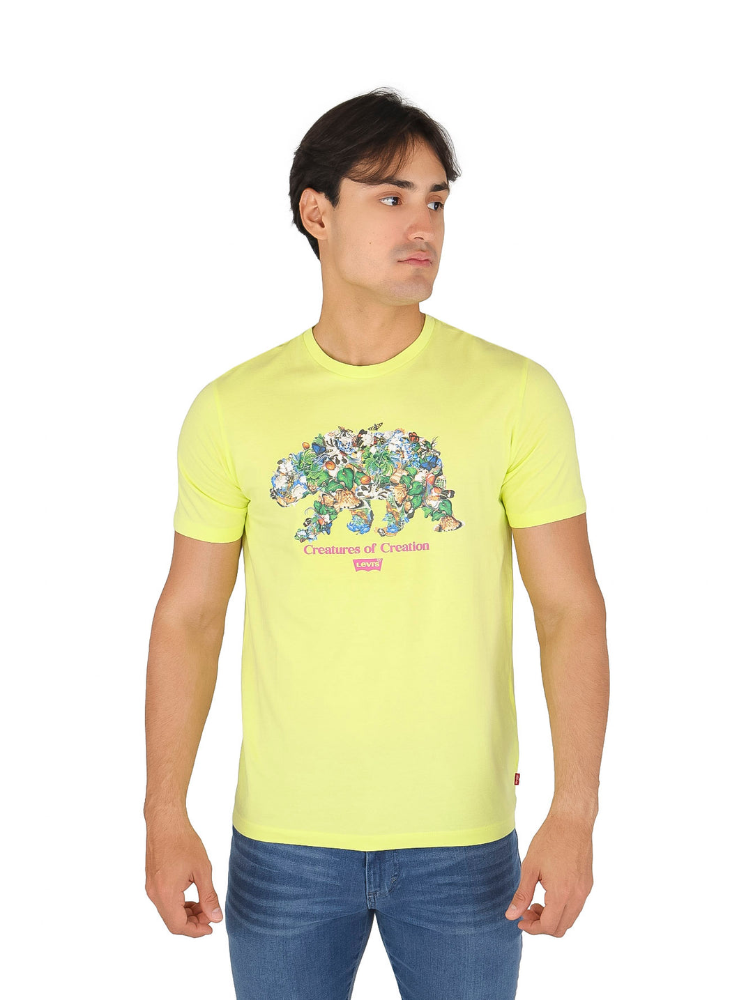 Hombre vistiendo una camiseta verde lima con estampado gráfico de animales y jeans azules.