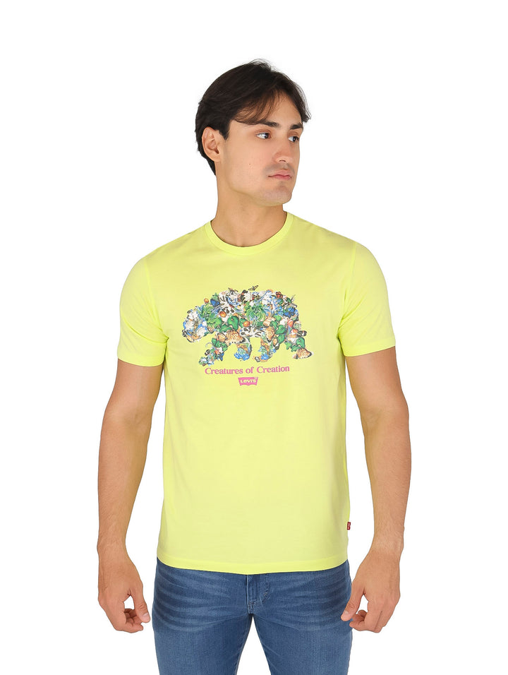 Hombre vistiendo una camiseta verde lima con estampado gráfico de animales y jeans azules.