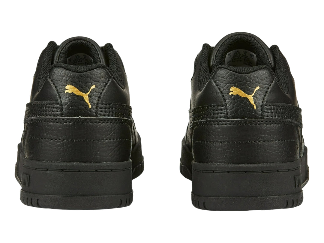 Tenis PUMA RBD Game Low JR en color negro con detalles dorados, vista lateral.