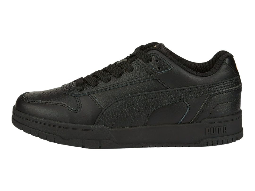 Tenis PUMA RBD Game Low JR en color negro con detalles dorados, vista lateral.