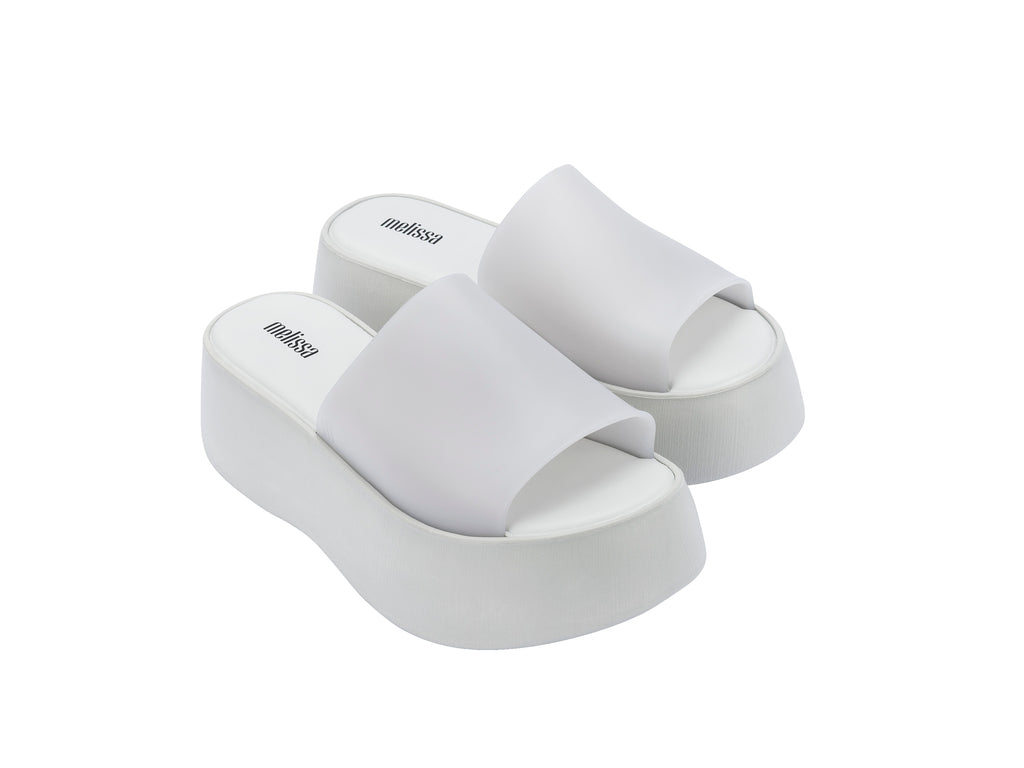 Par de sandalias Melissa blancas con plataforma alta y diseño minimalista de una sola banda.