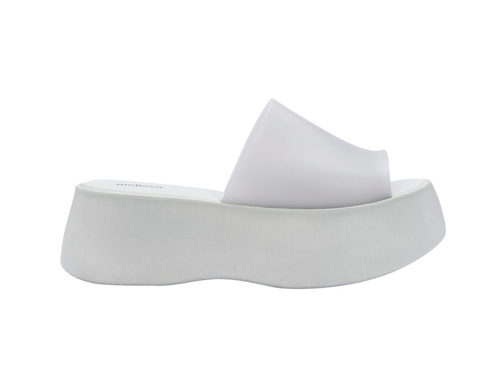 Par de sandalias Melissa blancas con plataforma alta y diseño minimalista de una sola banda.