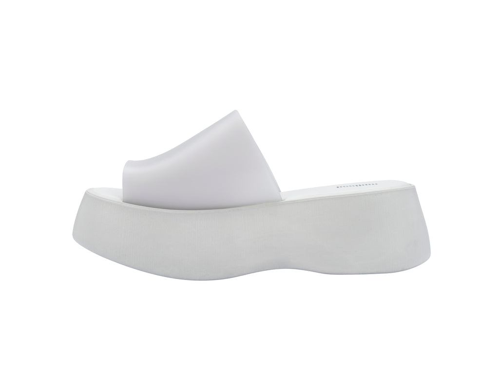Par de sandalias Melissa blancas con plataforma alta y diseño minimalista de una sola banda.