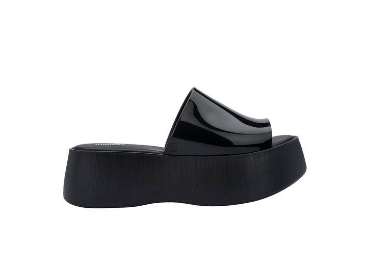 Sandalias negras de plataforma con correa brillante y suela gruesa mate.