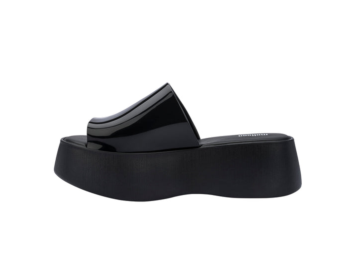Sandalias negras de plataforma con correa brillante y suela gruesa mate.