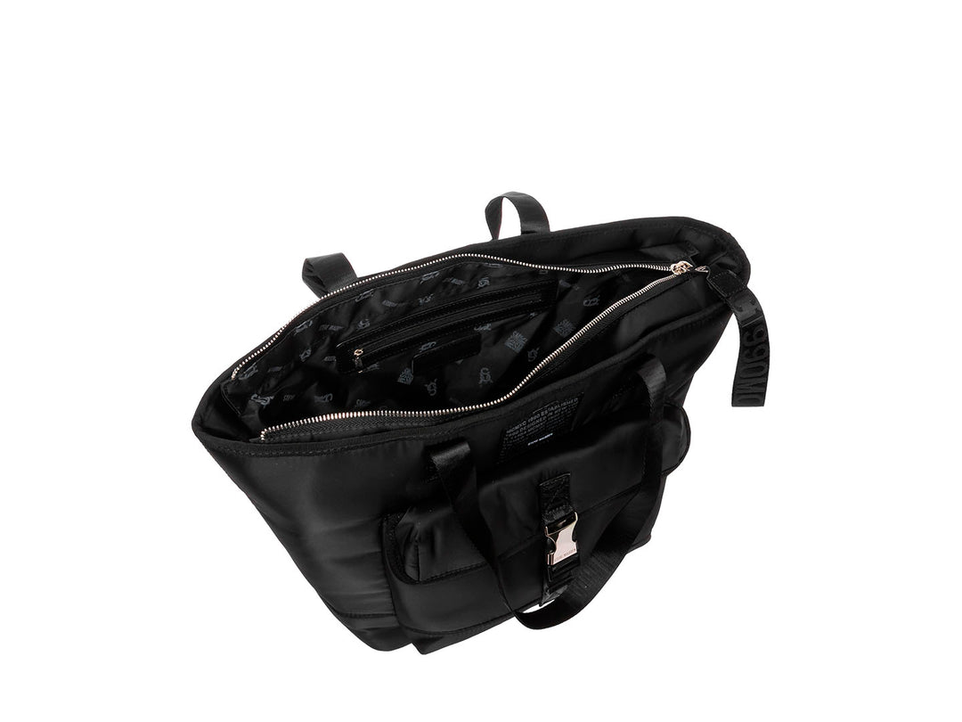 Bolsa tote negra de Steve Madden con bolsillo frontal, hebilla plateada y correas con texto.