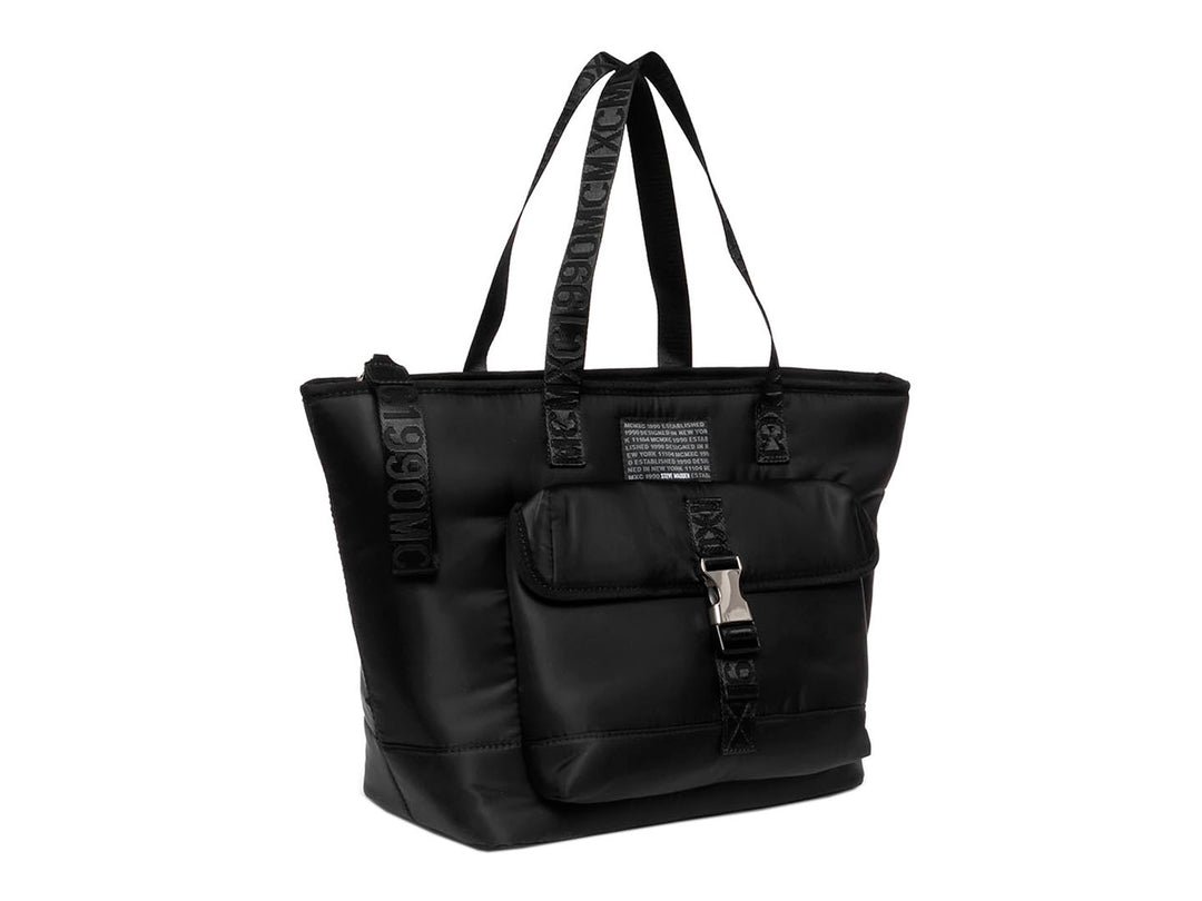 Bolsa tote negra de Steve Madden con bolsillo frontal, hebilla plateada y correas con texto.