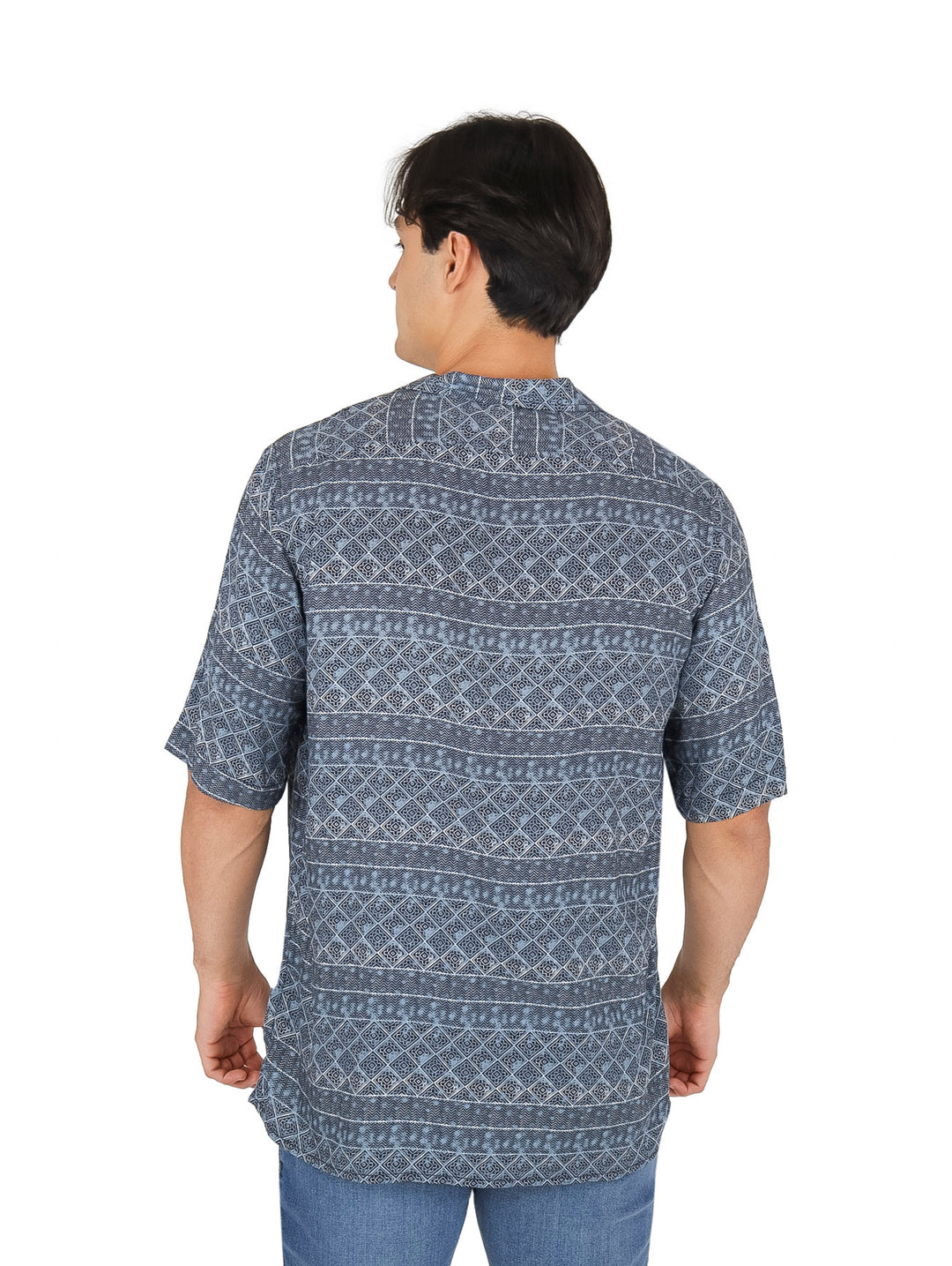Hombre vistiendo camisa azul de manga corta con estampado étnico geométrico en color blanco y botones frontales.