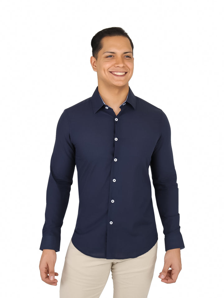 Hombre vistiendo una camisa de manga larga color azul marino con botones frontales y pantalones beige.