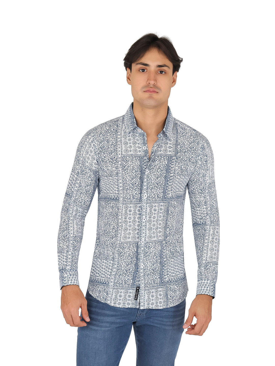 Hombre vistiendo camisa blanca de manga larga con estampados azules y pantalones vaqueros azules.