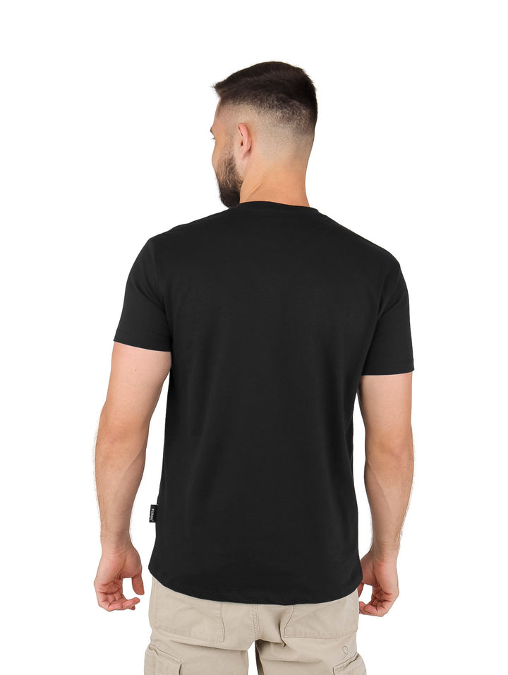 Hombre vistiendo playera negra de manga corta con estampado gráfico central de un rostro clásico y un tigre.