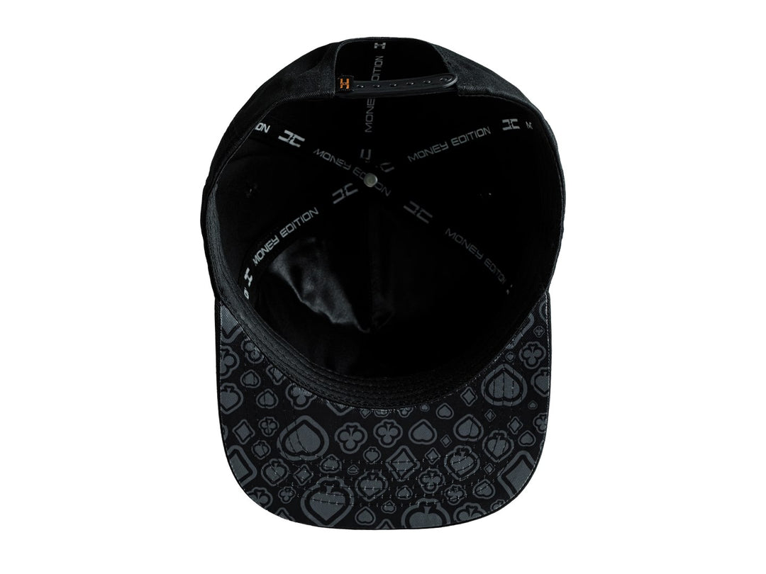 Gorra snapback color negro con un parche frontal rectangular que representa una carta del rey de picas.