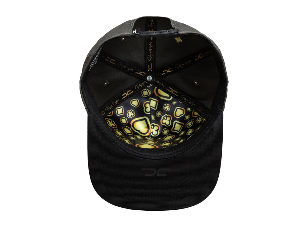 Gorra de béisbol color gris con visera negra y un parche rectangular frontal con diseño de carta del rey en dorado.