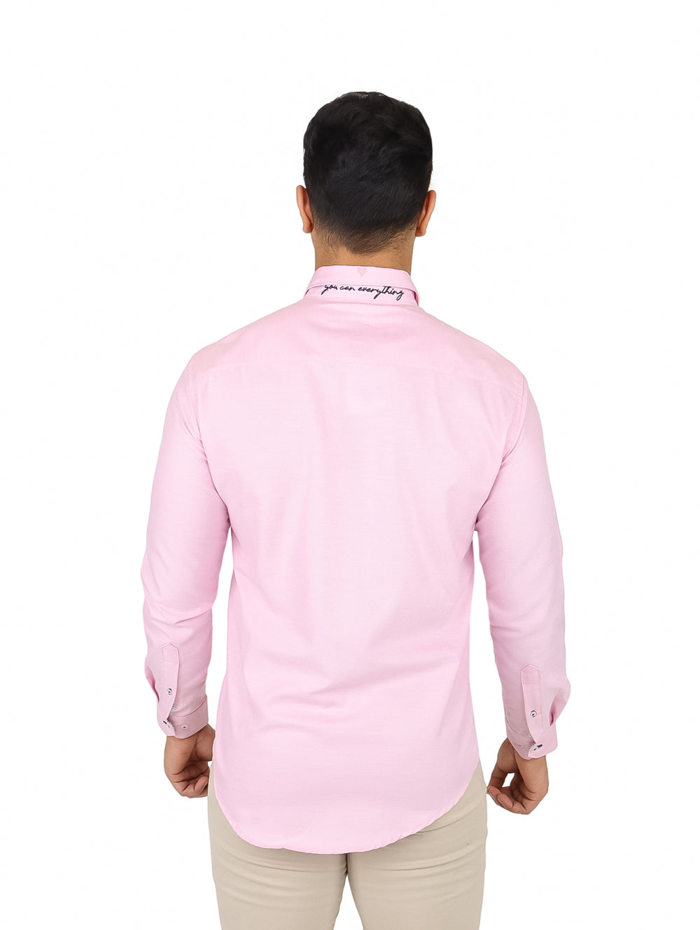 Hombre vistiendo una camisa de manga larga color rosa claro con cuello y botones frontales.