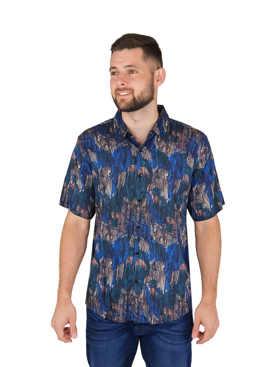 Hombre vistiendo camisa de manga corta azul con estampado abstracto y pantalones vaqueros.