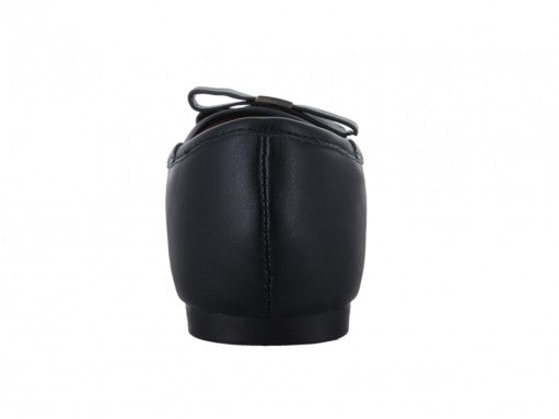 Zapato tipo baleta de charol negro con un detalle de moño blanco en la punta.