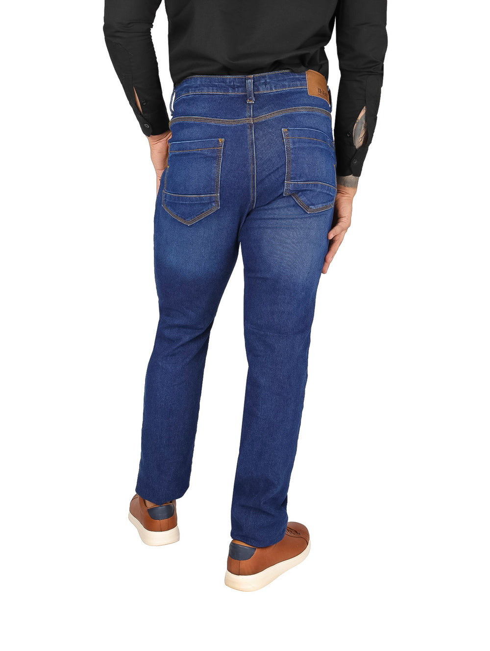 Hombre usando pantalones jeans color azul con efecto stone wash y detalles desgastados.