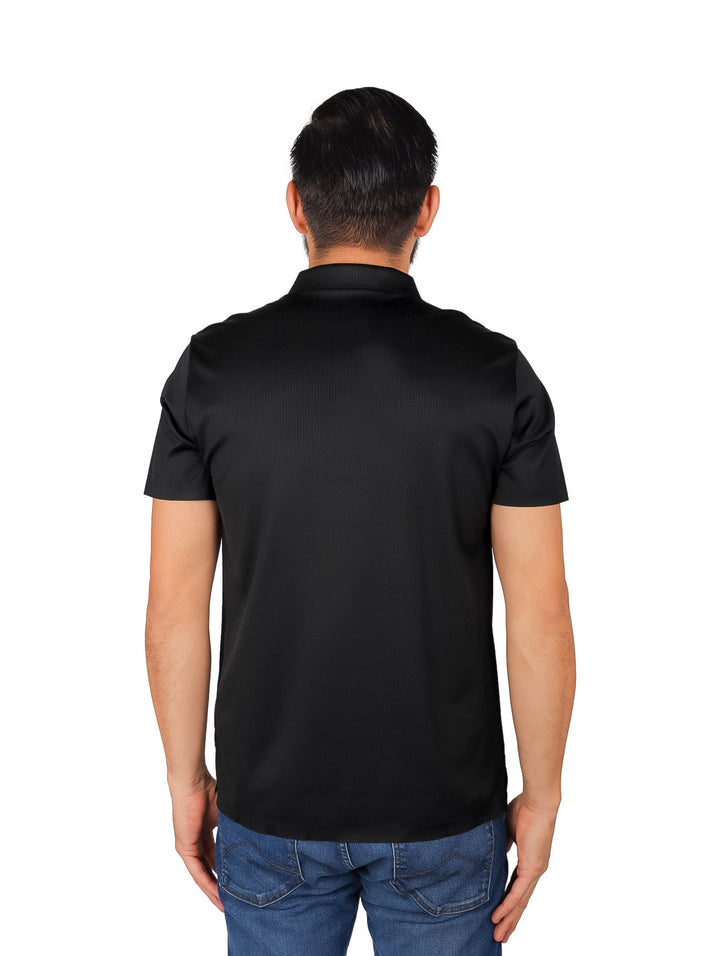 Hombre vistiendo una playera polo de color negro con cuello y manga corta.