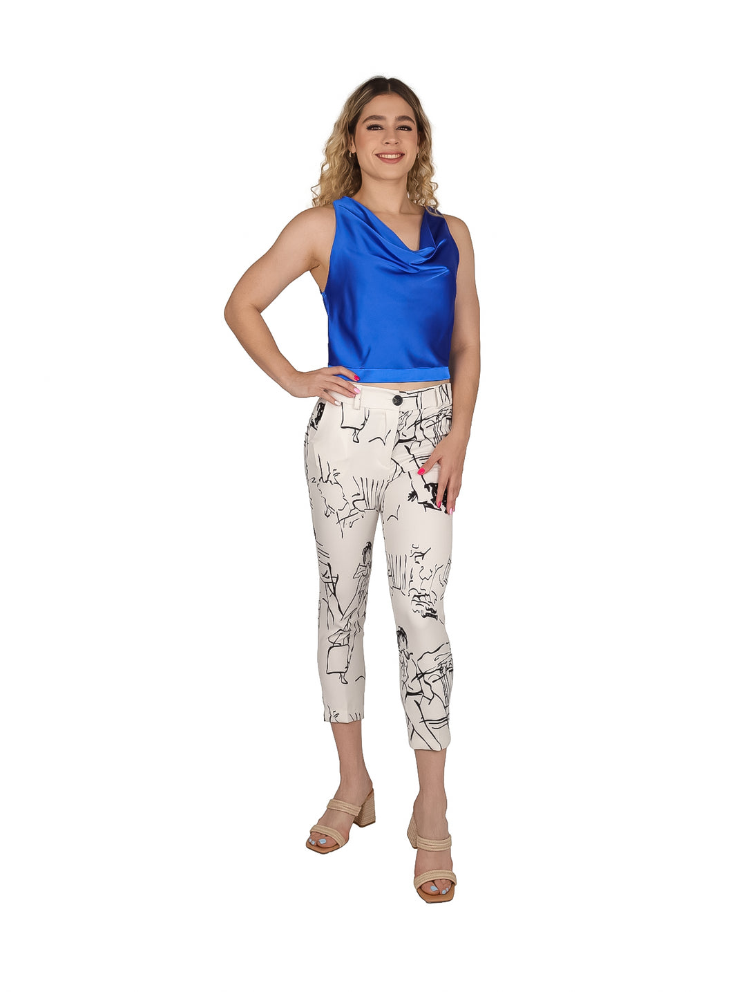 Mujer vistiendo un pantalón beige con estampado abstracto en negro y blusa azul.