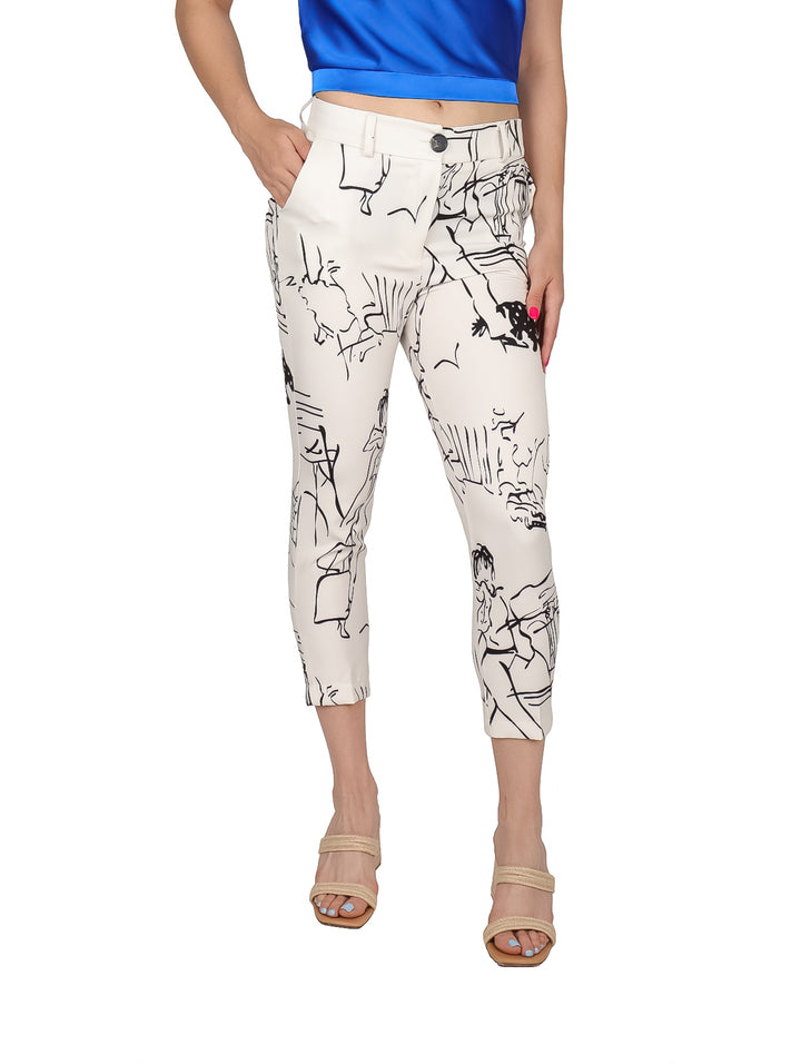 Mujer vistiendo un pantalón beige con estampado abstracto en negro y blusa azul.