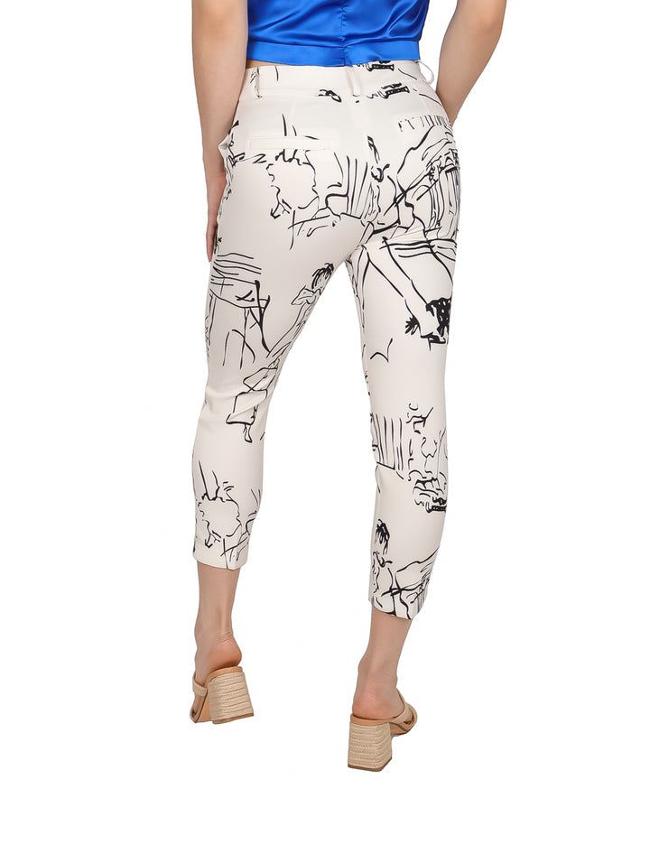 Mujer vistiendo un pantalón beige con estampado abstracto en negro y blusa azul.