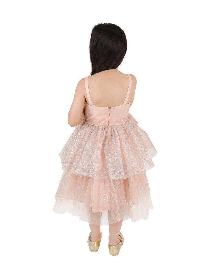 Niña con vestido elegante color rosa viejo con un gran moño frontal y falda de tul