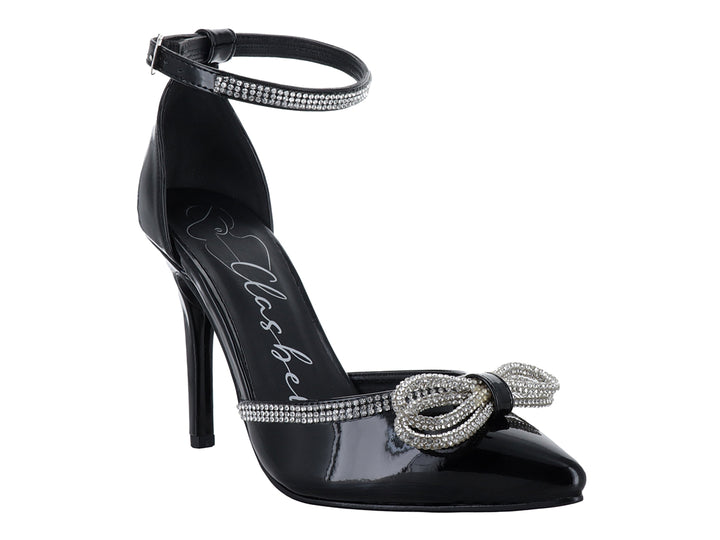 Zapatilla de tacón alto color negro brillante con moño y correa al tobillo decorados con cristales.