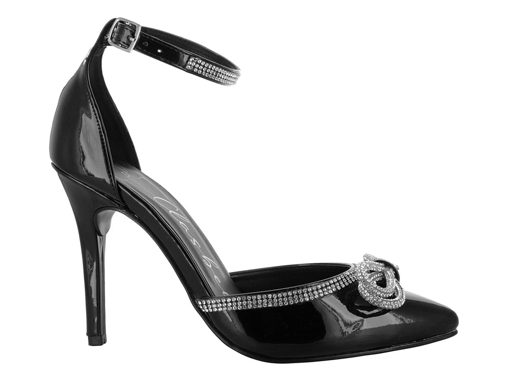 Zapatilla de tacón alto color negro brillante con moño y correa al tobillo decorados con cristales.