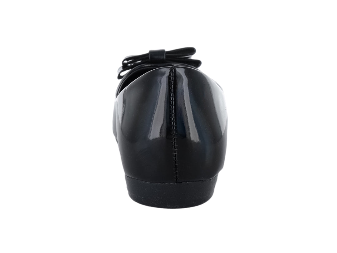 Zapato plano negro de charol brillante con moño decorativo y detalle dorado en la punta.