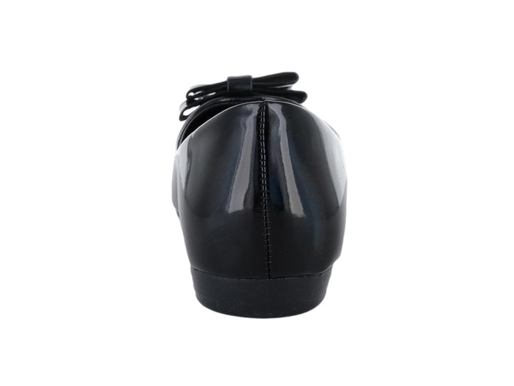 Zapato plano negro de charol brillante con moño decorativo y detalle dorado en la punta.